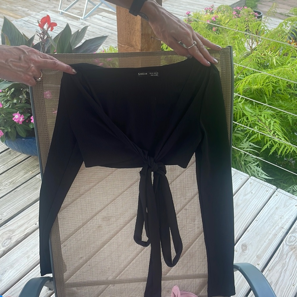 Black top with strings that tie and pink longsleeve top